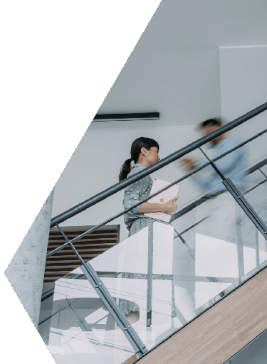 An Alterspective team member walking through a modern glass-railed office